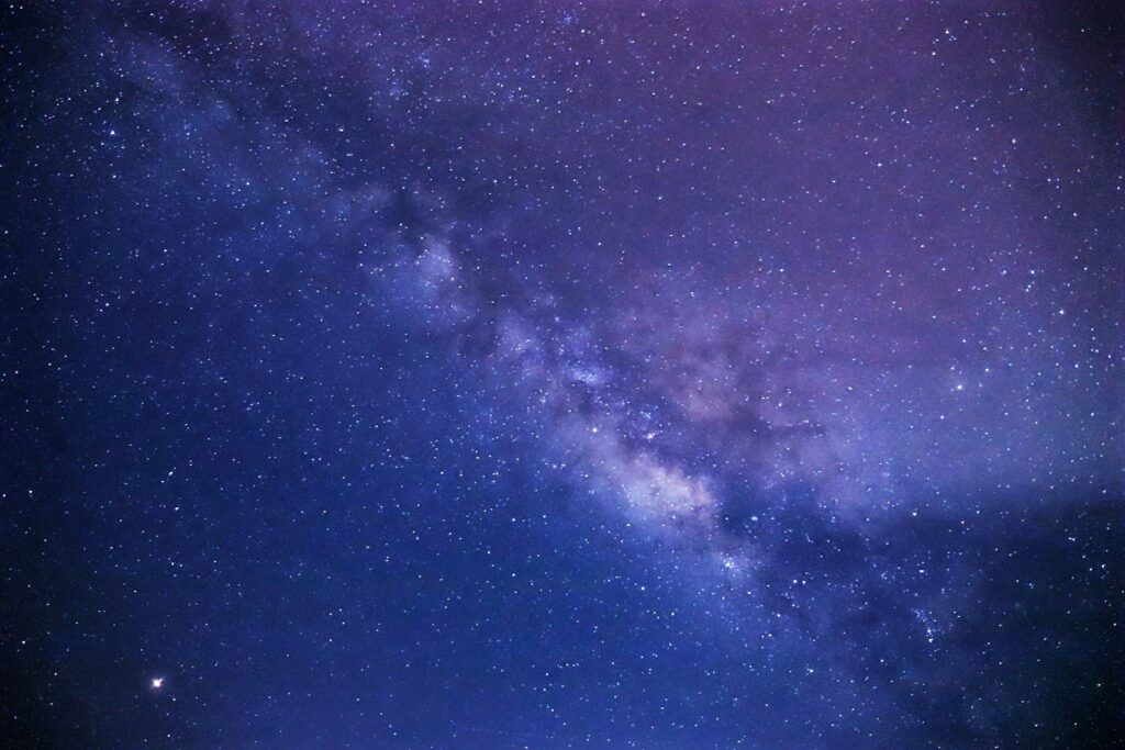 Via Láctea em tons de roxo e azul no céu noturno