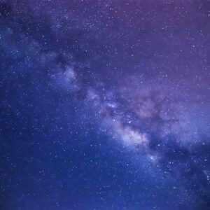 Via Láctea em tons de roxo e azul no céu noturno
